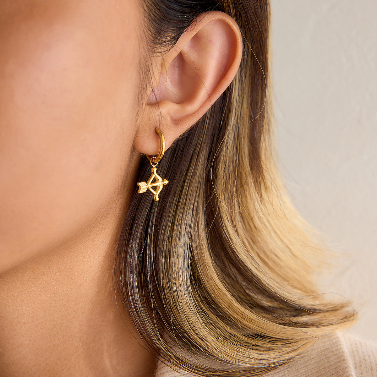 Cupid hoop earrings featuring a gold star charm, highlighting playful elegance and feminine charm.