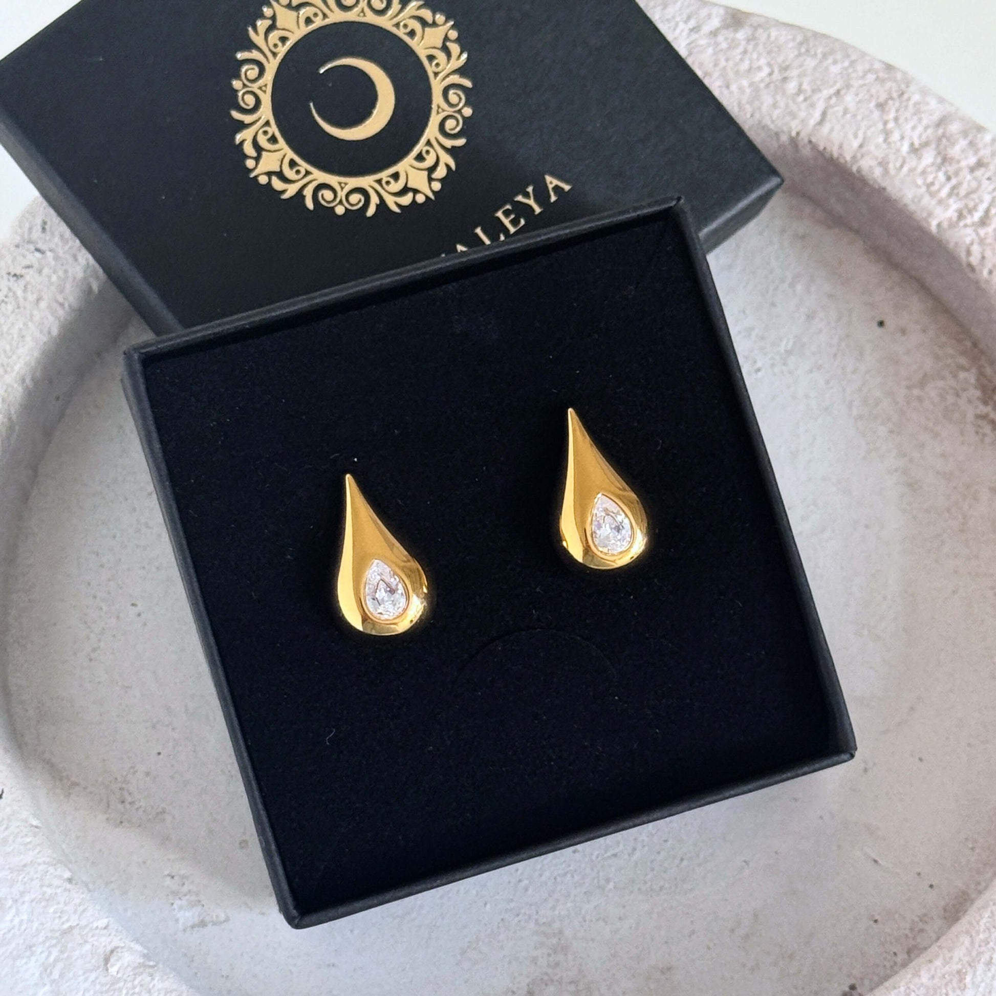 Classic Pear Cut CZ Stud Earrings in elegant gold setting, presented in a stylish black box.