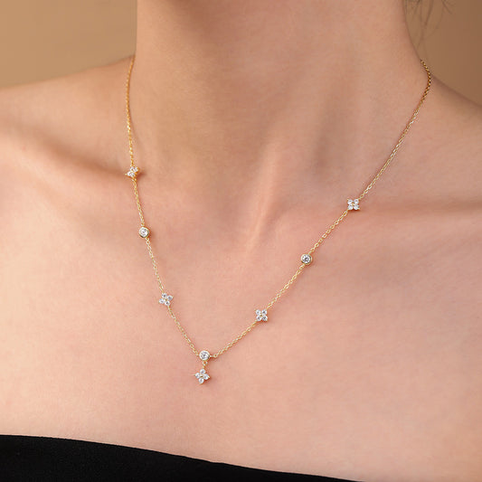 Gold Diana Flower Necklace with small diamonds on a person's neck against a beige background - Kataleya jewellery