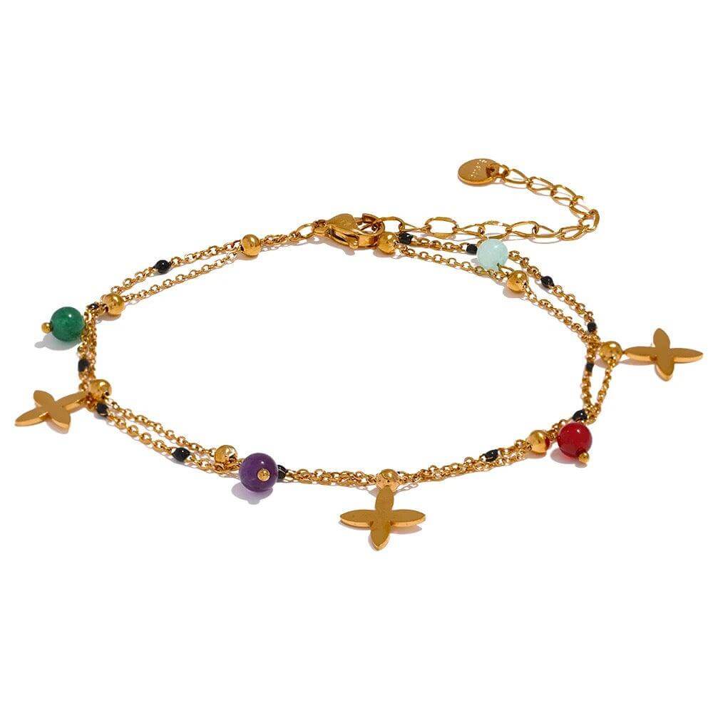 The Huacachina Anklet, embellished with colorful beads and golden flowers, is available in gold from Kataleya.