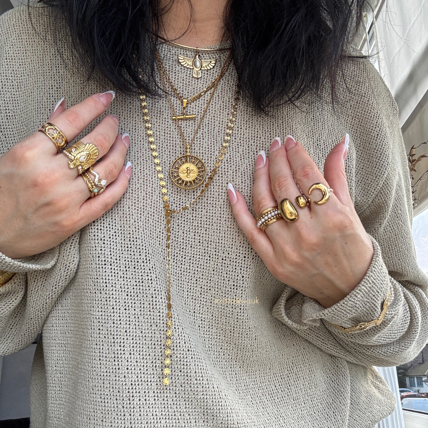 Long Disc Lariat Necklace worn with rings and layered jewelry against a neutral sweater.