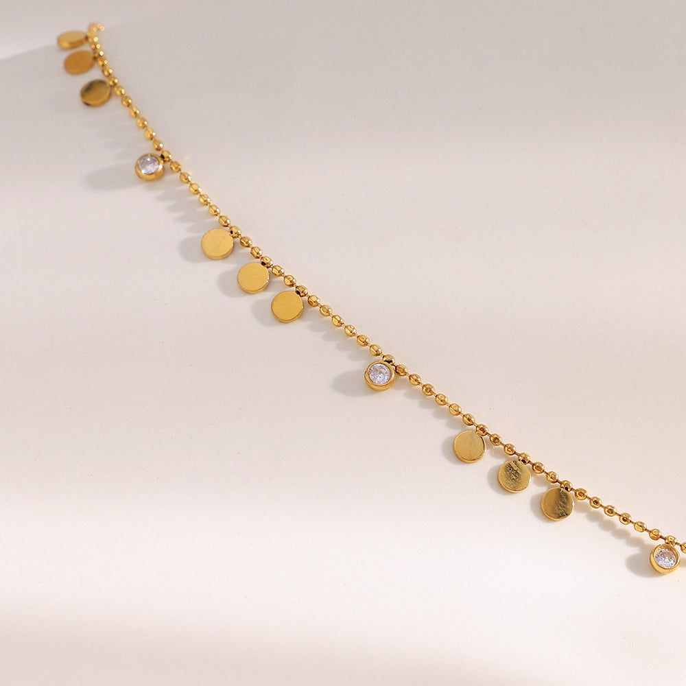 Disc Charm Necklace featuring delicate gold chain with small polished discs and sparkling accents.