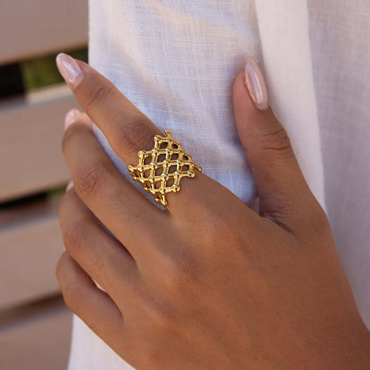 Woman wearing a Mesh Open Ring featuring a lattice-style design in gold, showcasing modern and stylish jewelry.