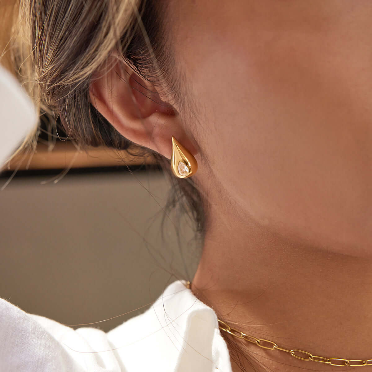 Classic Pear Cut CZ Stud Earrings worn by a model, showcasing elegant pear-cut design in a chic outfit.