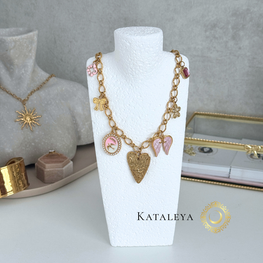Pink Wings Charm Necklace showcasing gold chain and pink charms on a display mannequin