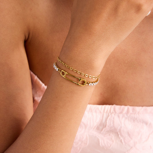 Close-up of a stylish Safety Pin Tennis Bracelet on a wrist, featuring sparkling crystals and gold safety pin accent.