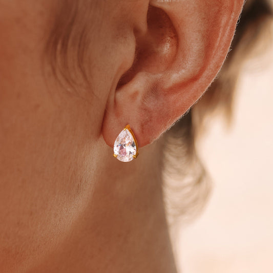 Close-up of a model wearing large teardrop CZ stud earrings, showcasing their elegant design and clarity.