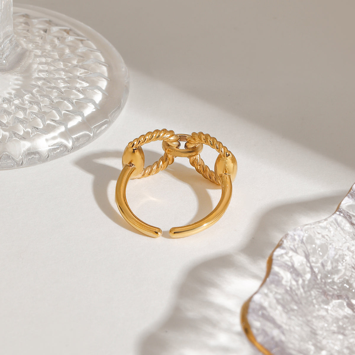 Twist Chain Ring in 18ct gold plated stainless steel on a surface, showcasing its elegant design.