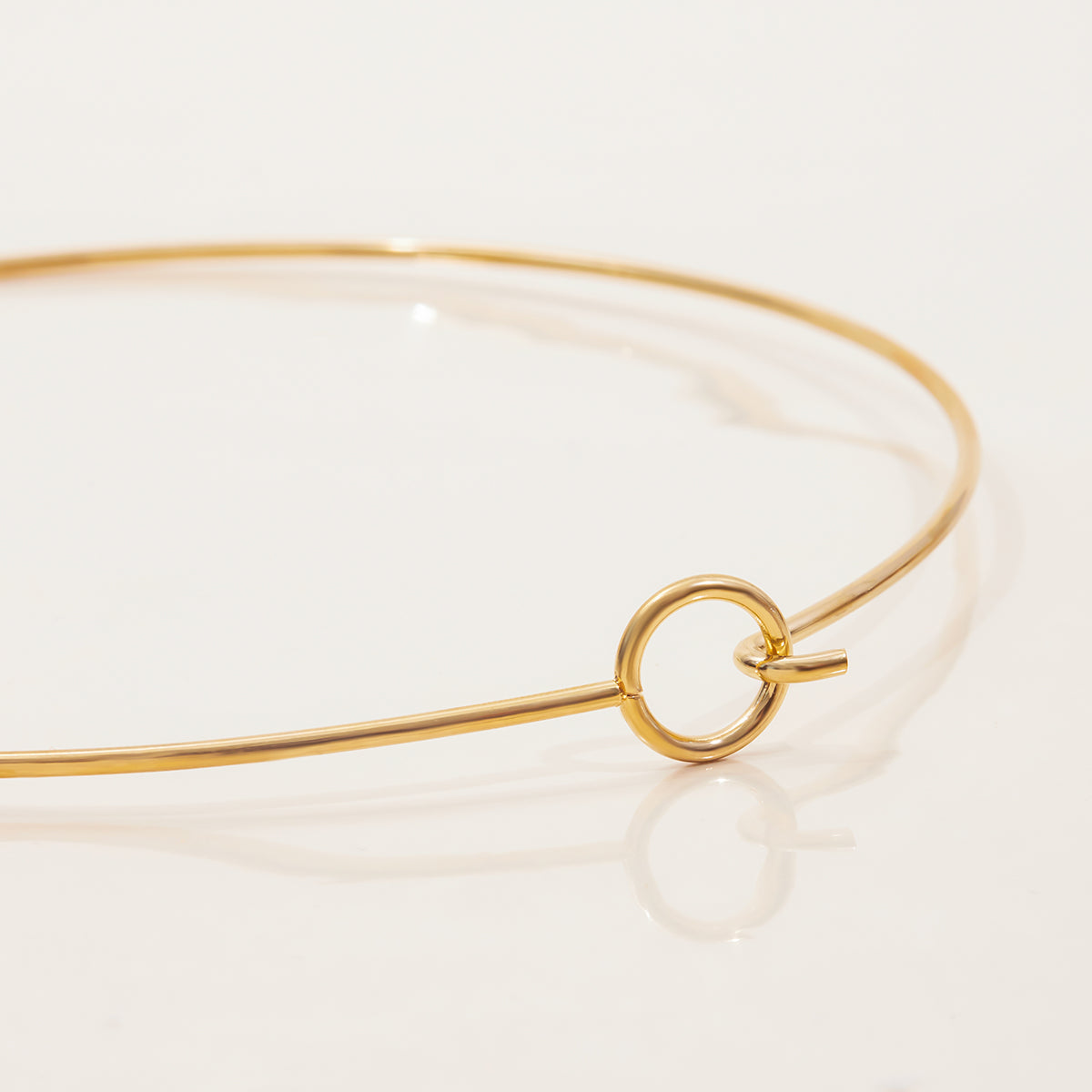Close-up of a Minimalist Wire Choker featuring a gold-tone circular clasp and sleek design, waterproof and tarnish free.